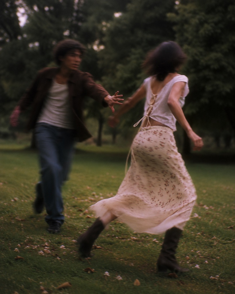 Two figures chasing in a park